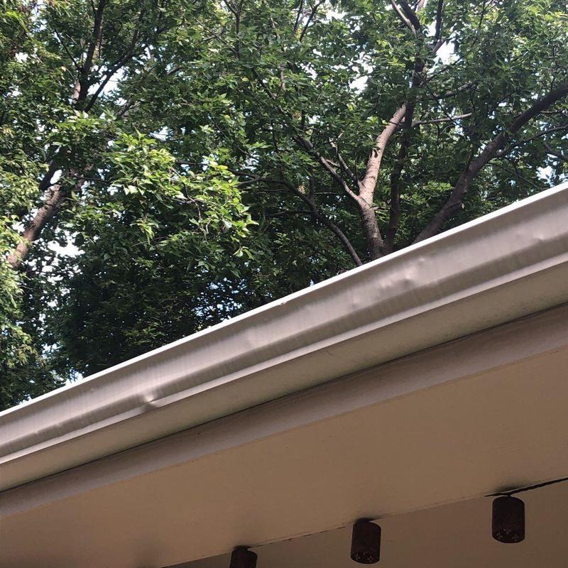 Gutter system with minor dents under tree canopy