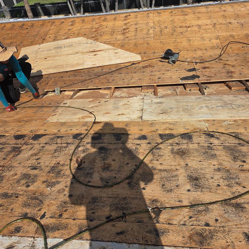 Plywood roof decking replacement with tools and worker