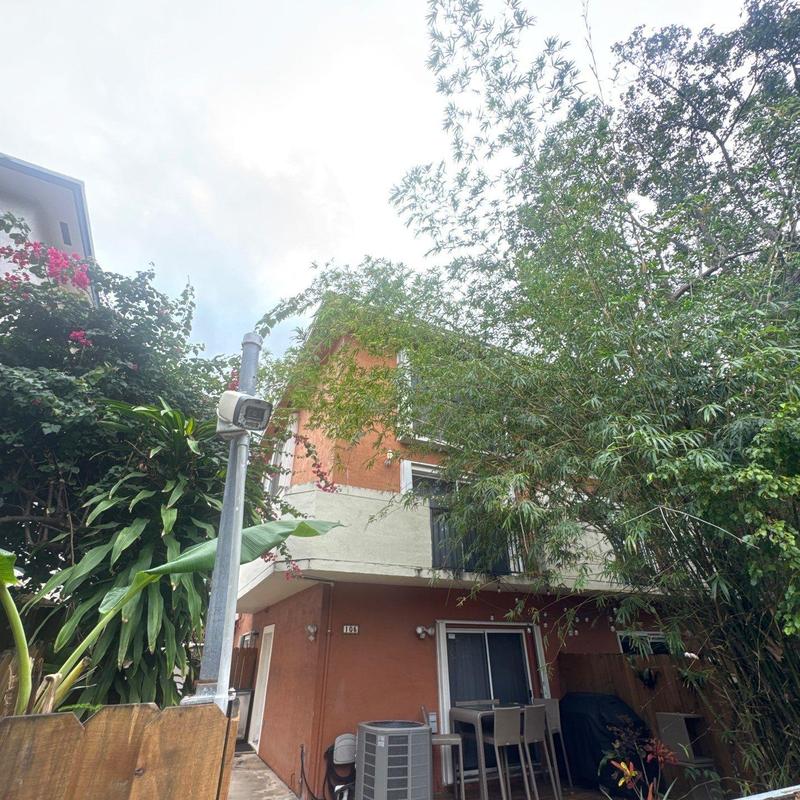 Security camera mounted on pole near residential building