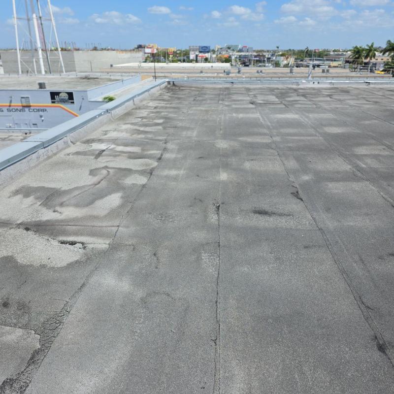 Commercial flat roof with visible wear and damage Commercial flat roof with visible wear and damage