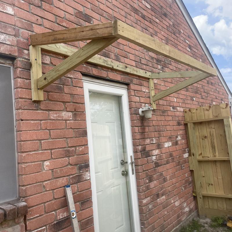 Treated lumber porch cover frame above door