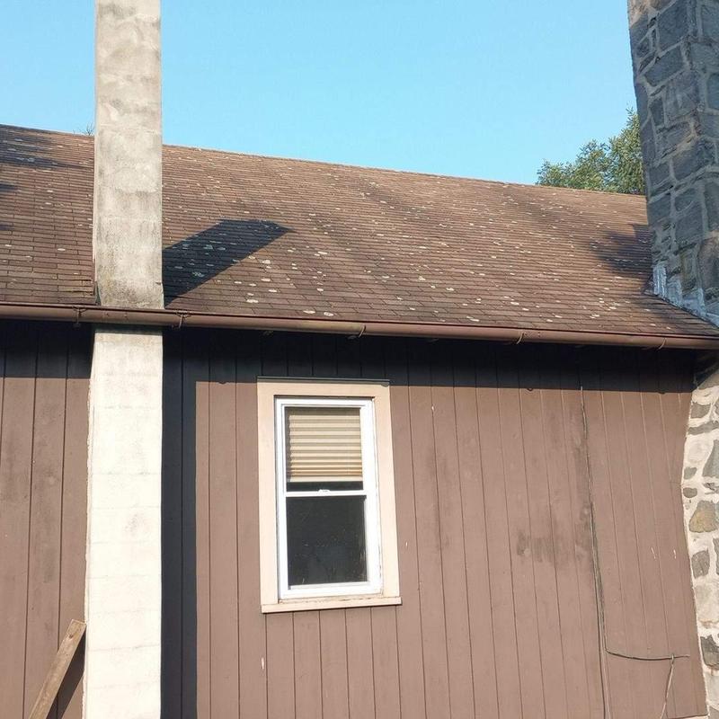 Asphalt shingle roof with weathered spots on residential house Asphalt shingle roof with weathered spots on residential house