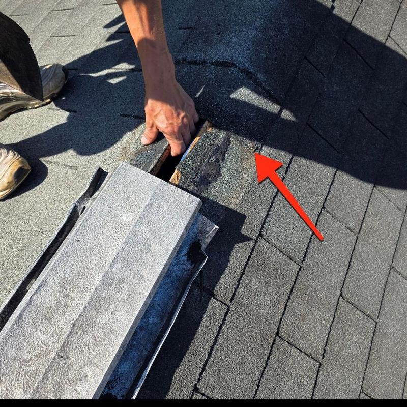 Roof ridge shingles with damaged area and hand inspecting Roof ridge shingles with damaged area and hand inspecting