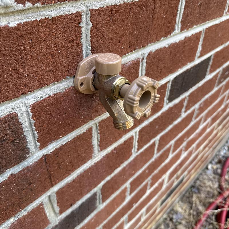 Frost proof hose bib mounted on brick wall