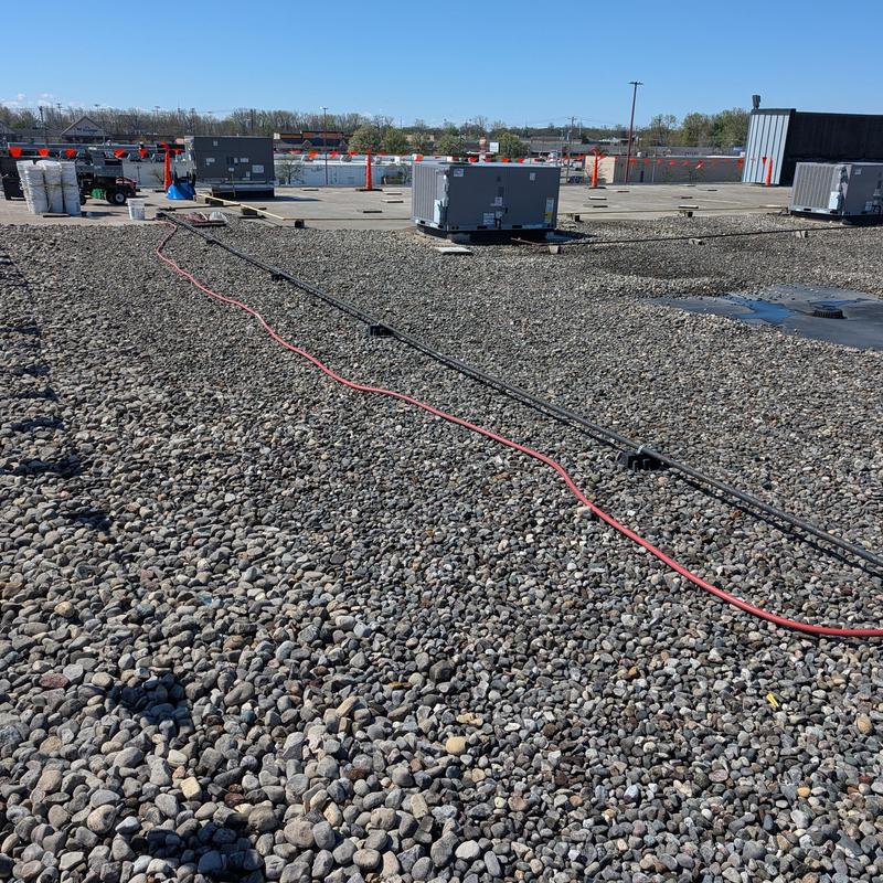 TPO single ply roof with loose gravel and HVAC units