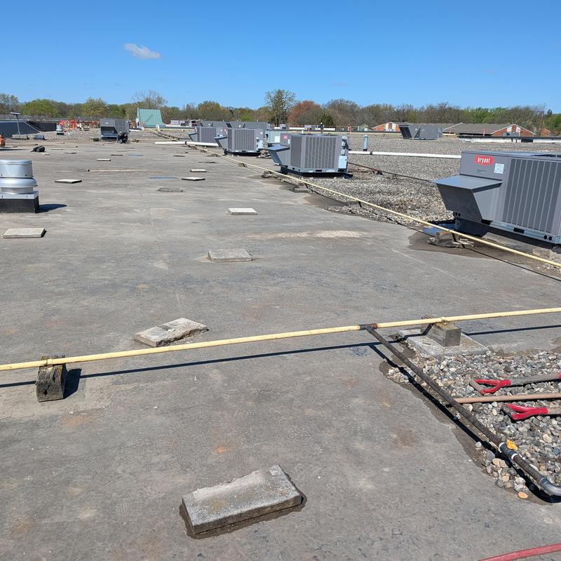 TPO single-ply roof surface clearing rocks and debris