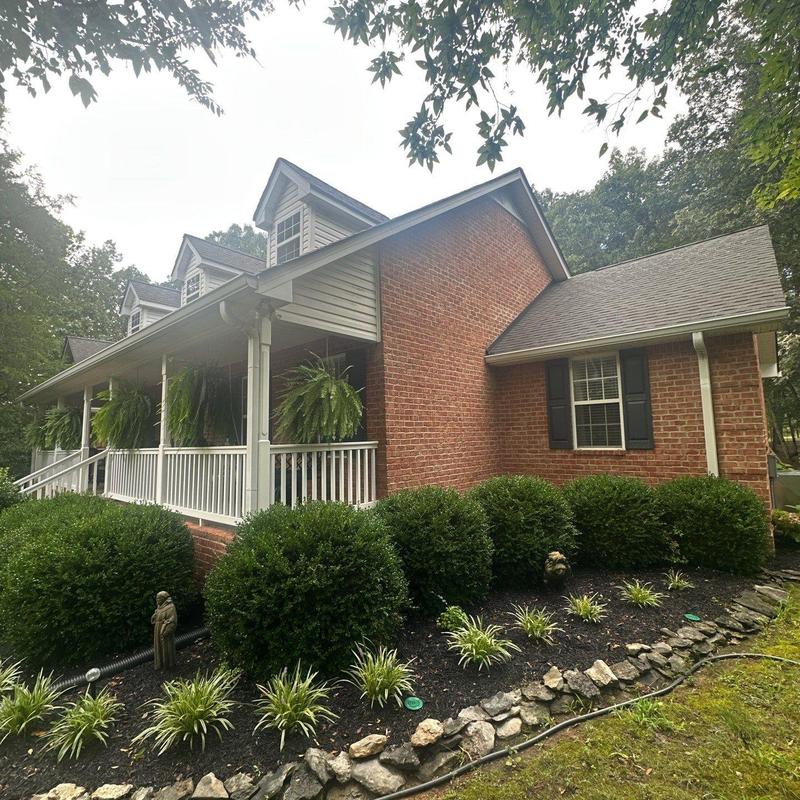 Asphalt roof with hail damage on brick house exterior