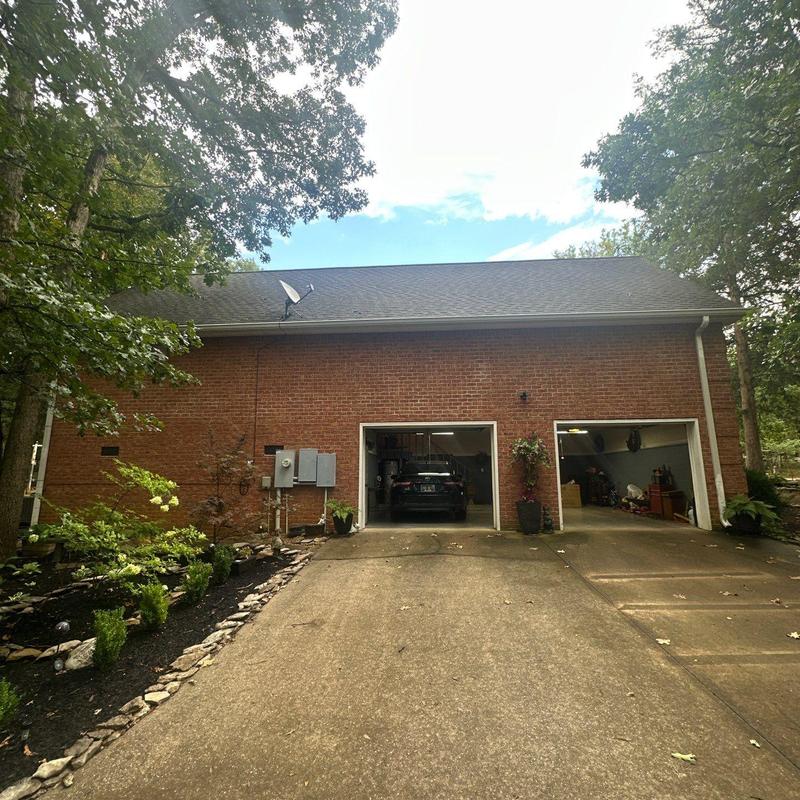 Asphalt shingle roof with hail damage and driveway