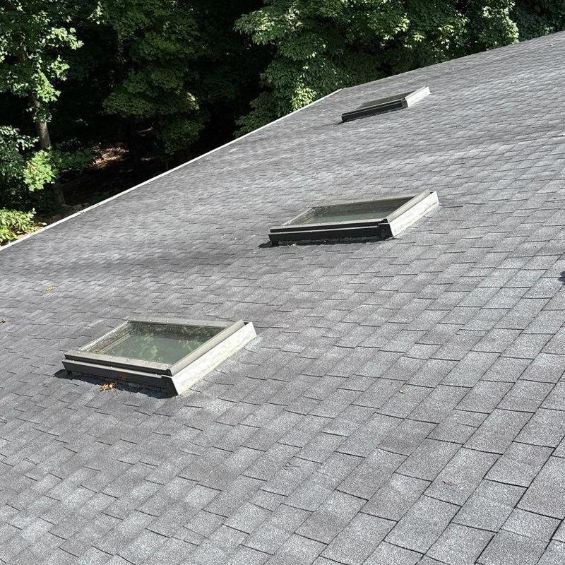 Asphalt roof shingles with hail damage near skylights