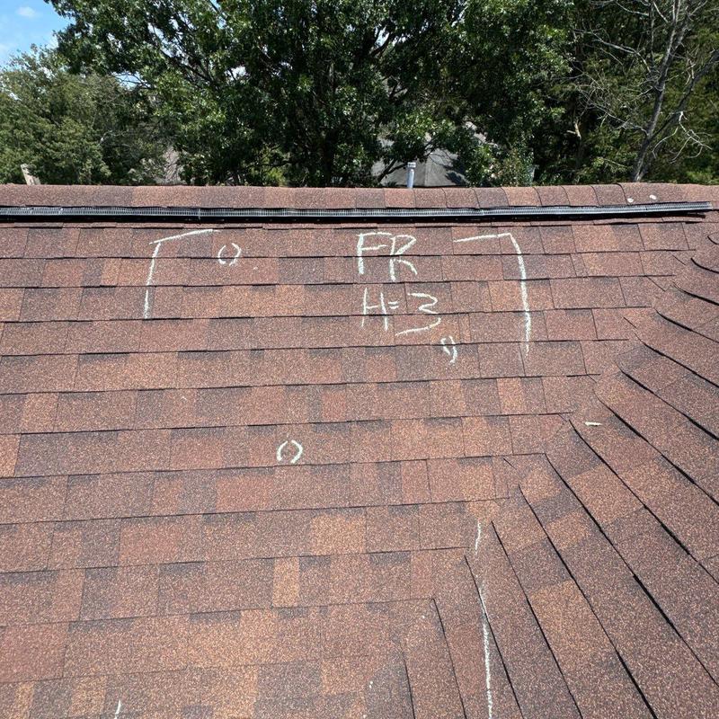 Asphalt shingle roof hail damage marked for repair