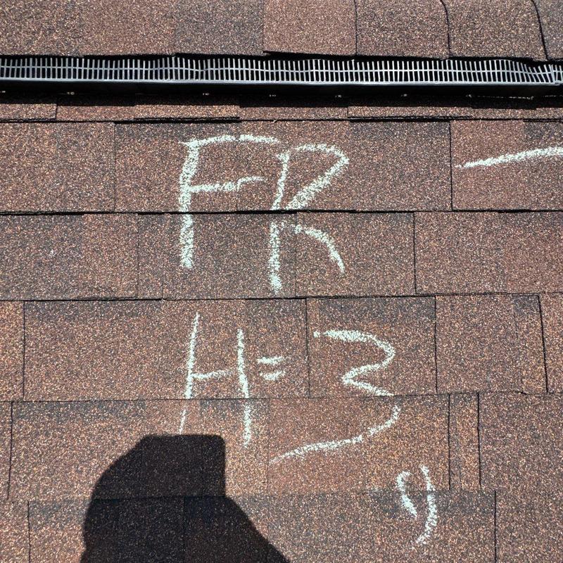 Asphalt roof shingles with hail damage markings