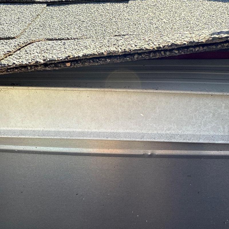 Roof shingles and metal flashing hail damage close-up