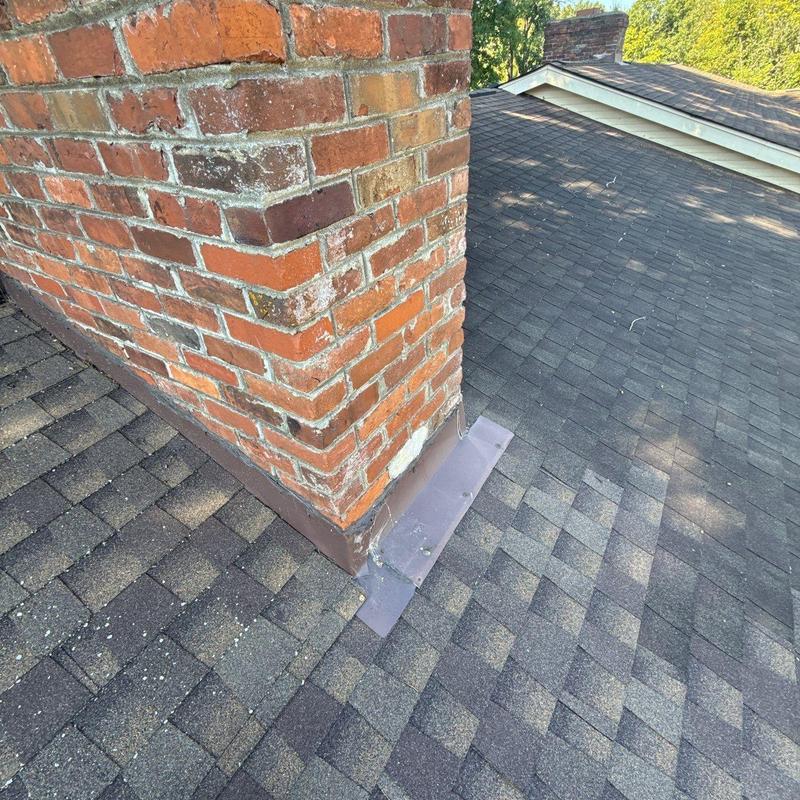 Chimney flashing installation on asphalt shingle roof