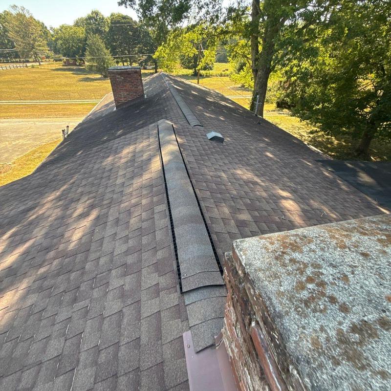 Asphalt shingle roof with ridge vent and chimney