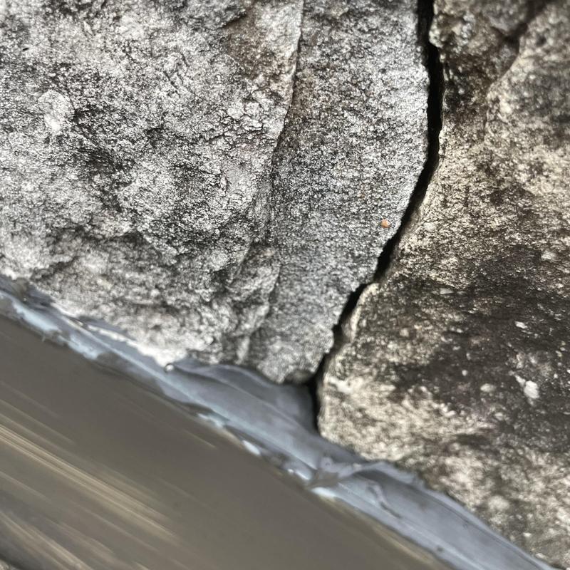 Chimney step flashing with sealant crack repair close-up Chimney step flashing with sealant crack repair close-up