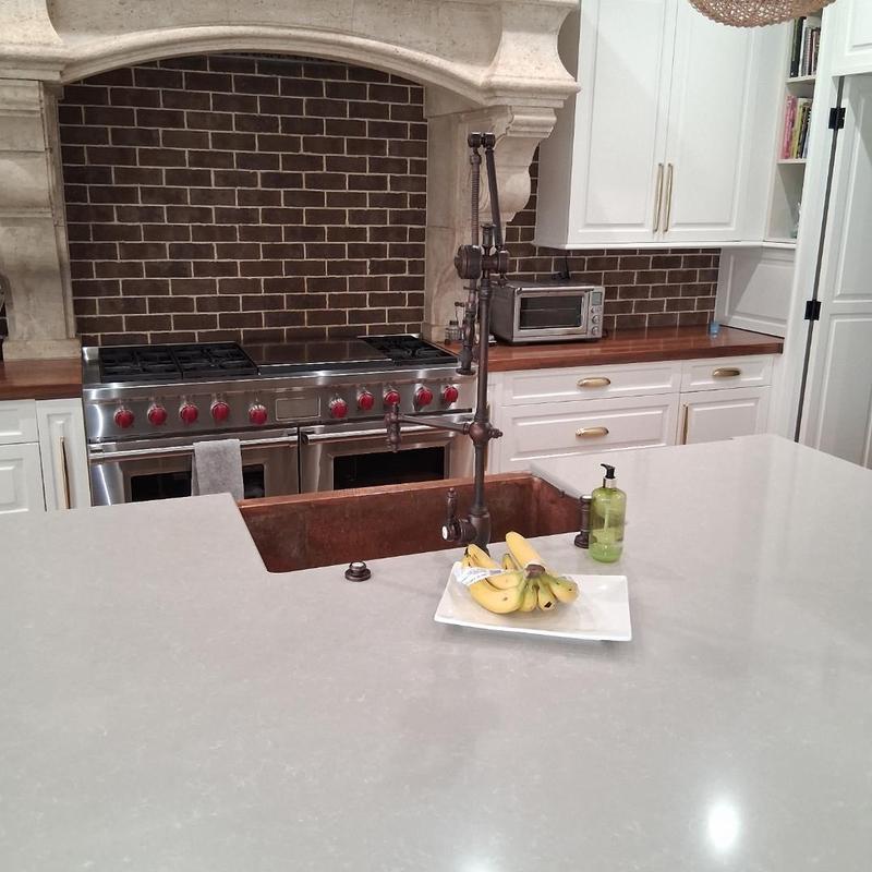 Copper kitchen sink with tall industrial faucet installed