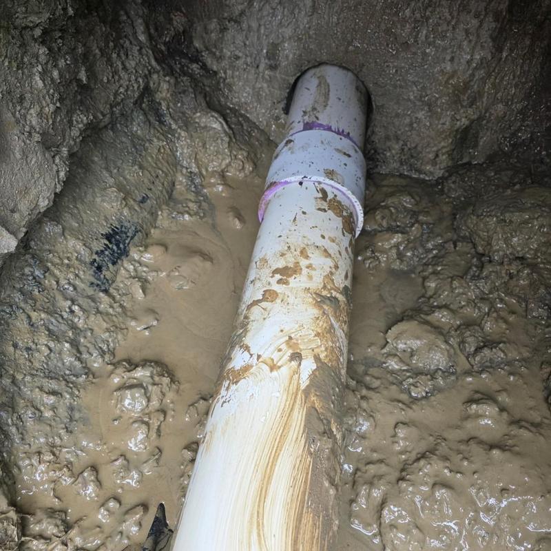 Sewer pipe installation with cored footing hole