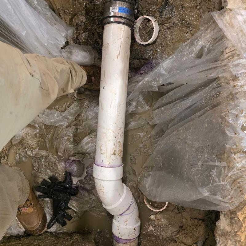 PVC sewer pipe with coupler in muddy trench