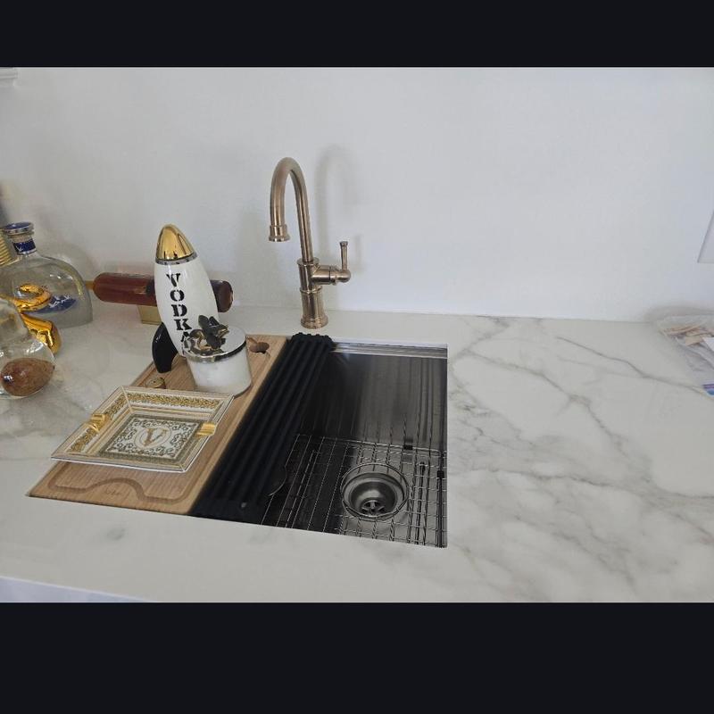 Kitchen sink and brass faucet with accessories on countertop