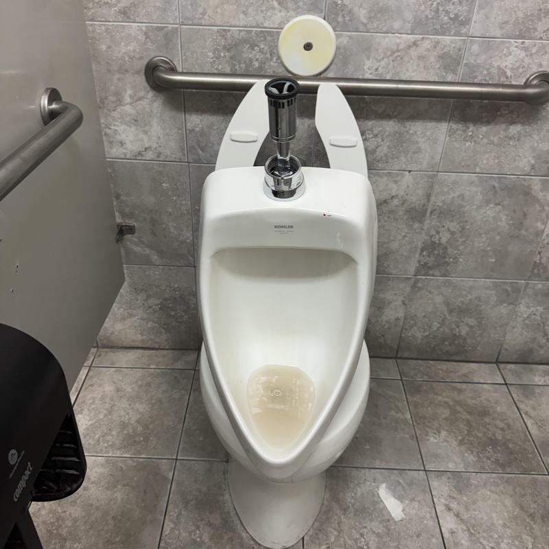 Urinal with sensor flush valve in commercial restroom Urinal with sensor flush valve in commercial restroom