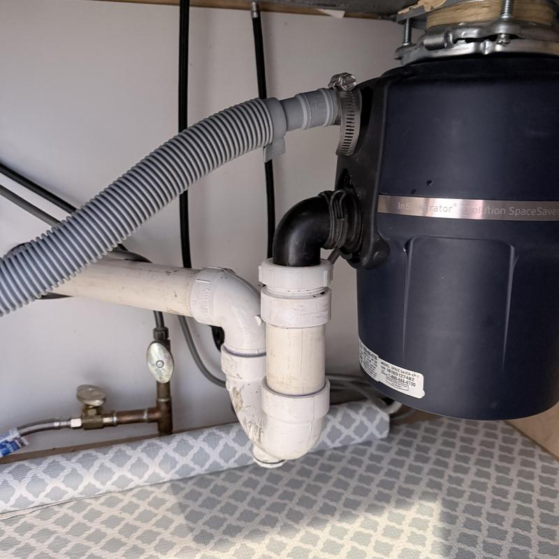 Garbage disposal plumbing and drain pipes under sink