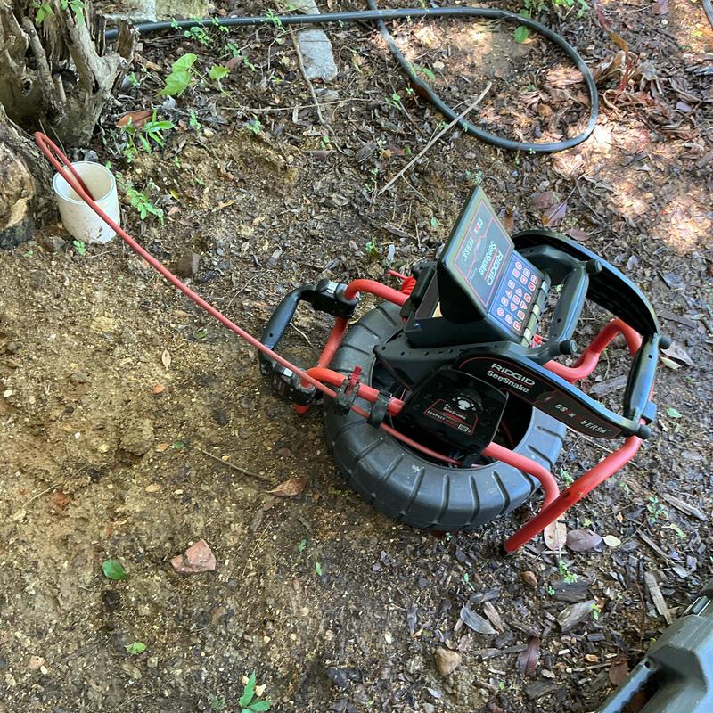 Sewer line inspection camera with cable cleaning tool