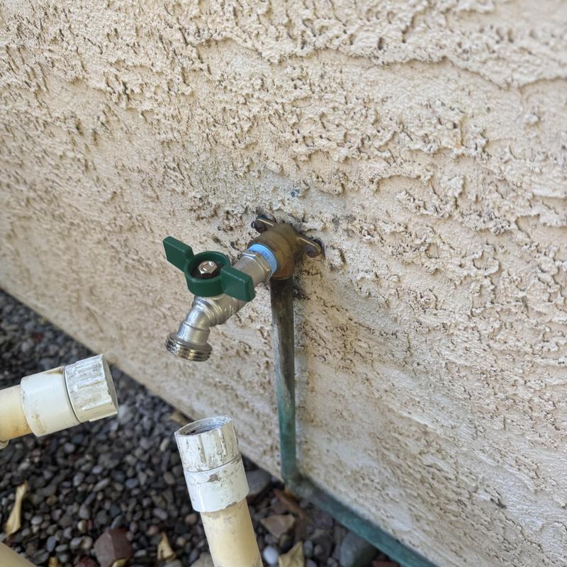 Stainless steel hose bib with green ball valve on wall Stainless steel hose bib with green ball valve on wall