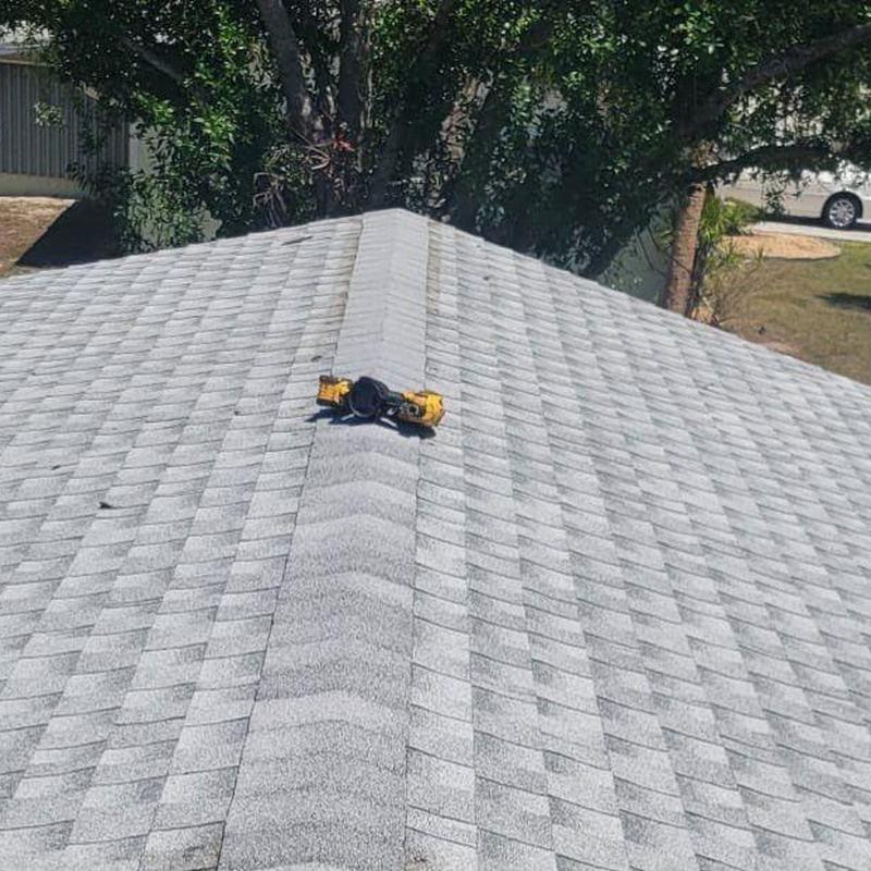 Shingle roof ridge with new shingles and tools