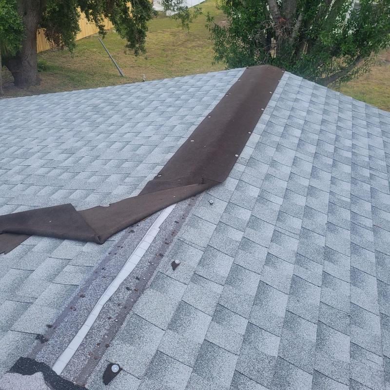Shingle roof ridge with underlayment exposed during repair