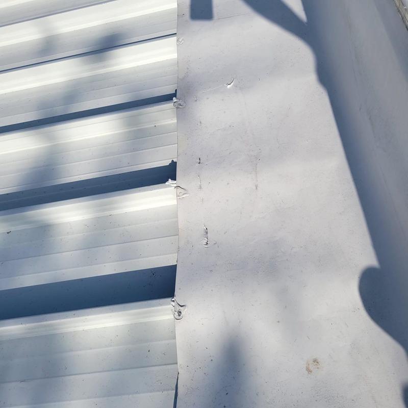 TPO roof membrane with damaged patches and rusted screws