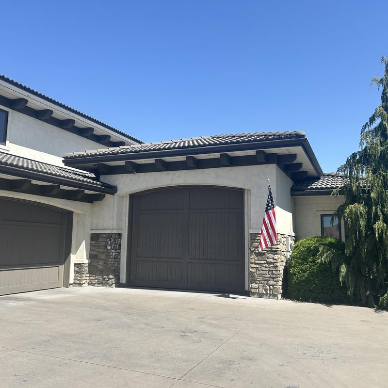 Tile roof with stone facade and garage doors