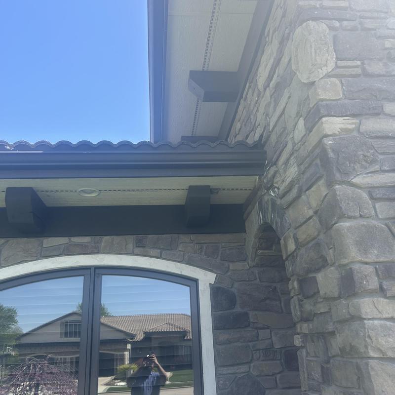 Tile roof and gutter system with stone wall exterior