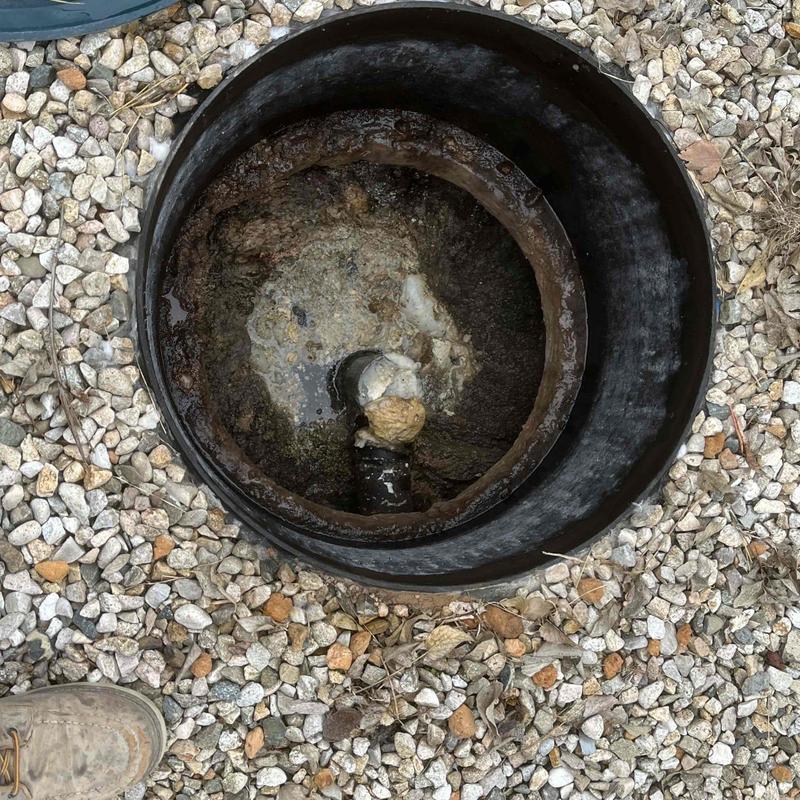 Sewer cleanout pipe in gravel bed with cap removed