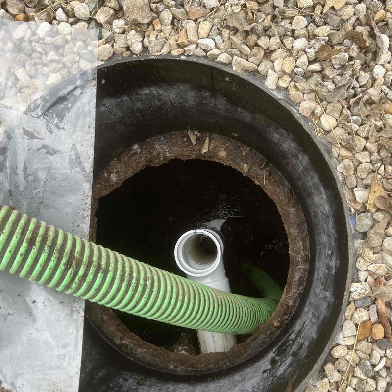 Septic tank cleaning with green hose and pipe
