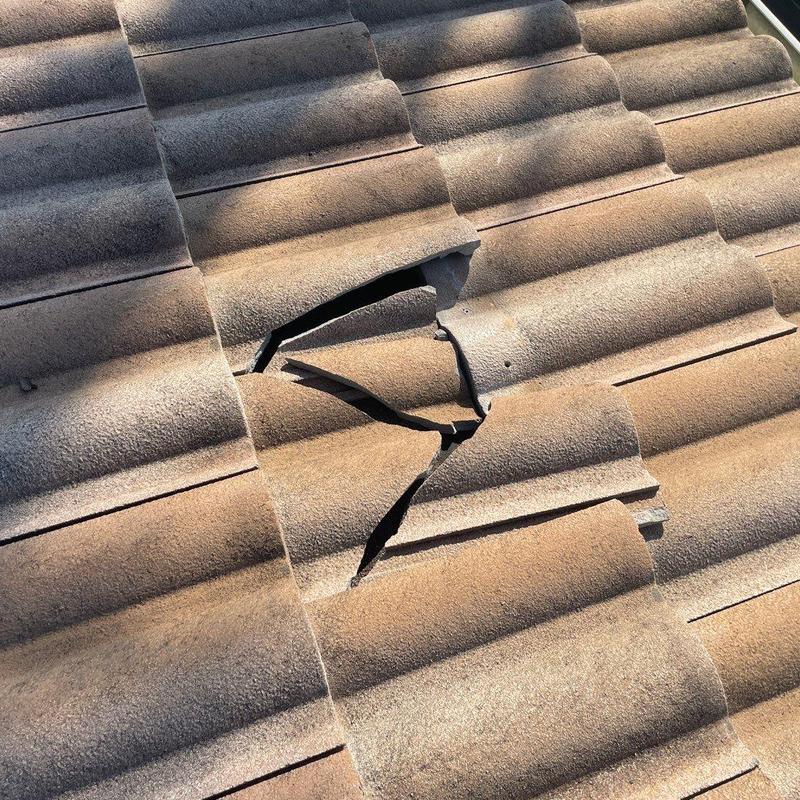 Concrete roof tile with visible cracks and damage