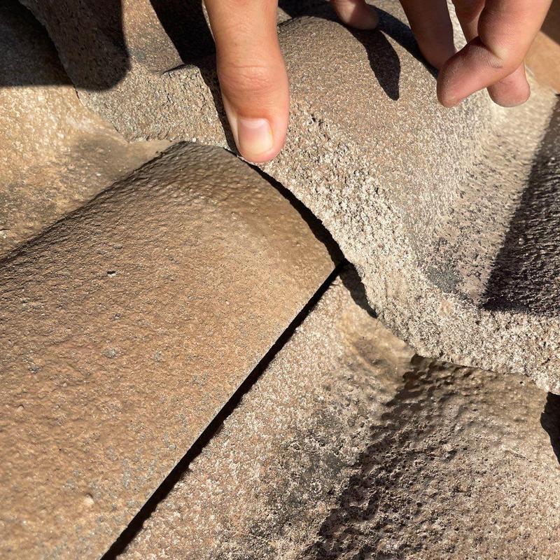Concrete tile roof with damaged and lifted tile