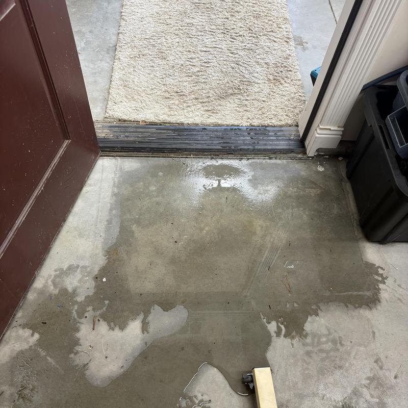 Garage concrete floor with water spill near door threshold