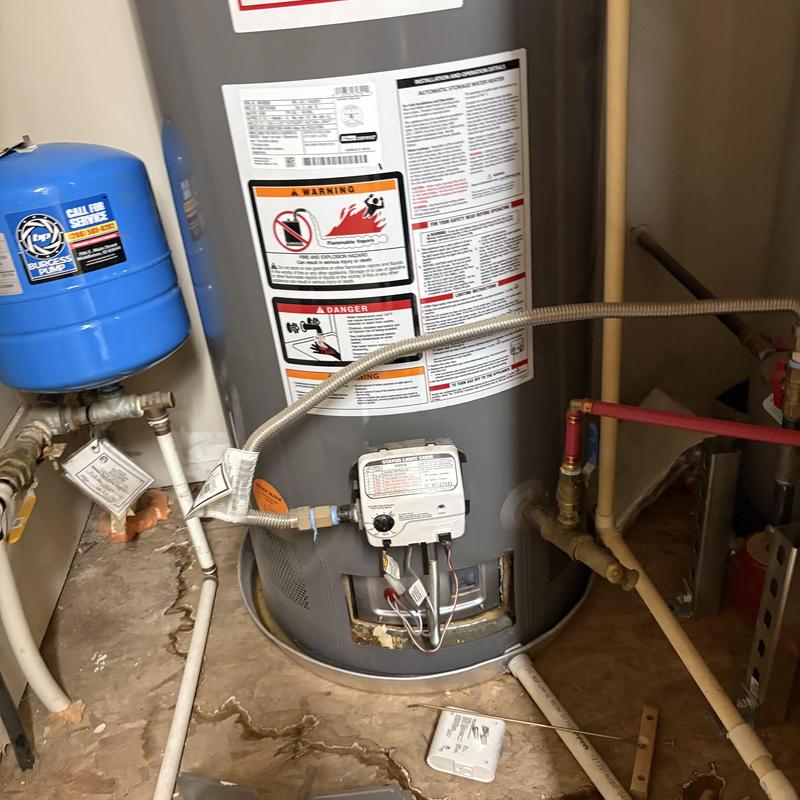 50 gallon water heater with connected plumbing and gas line