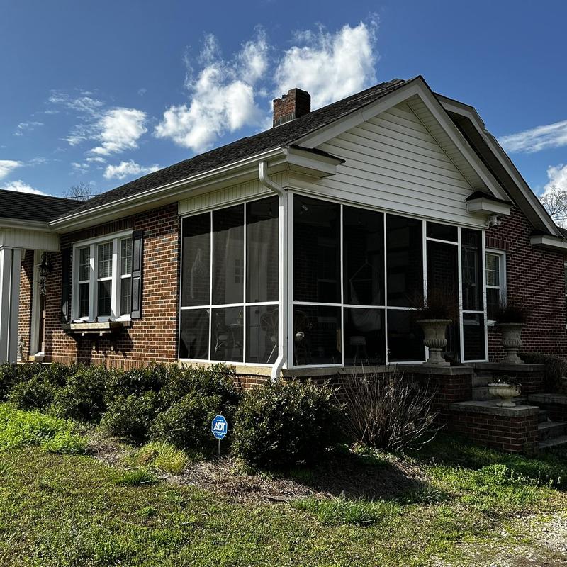 Asphalt shingle roof with fallen tree limb grazing side