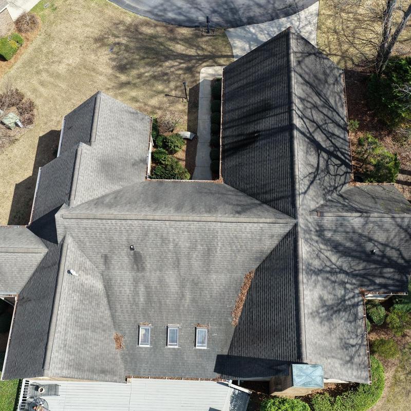 Asphalt shingle roof with skylights and leaf debris