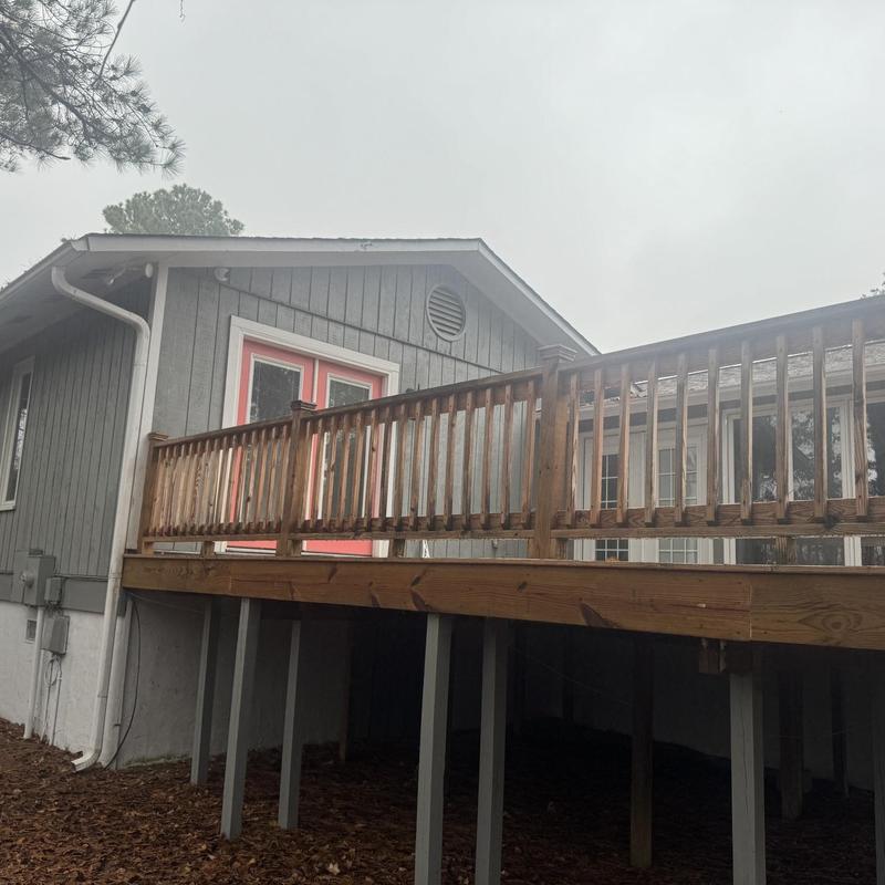 Wooden deck railing and support posts on house exterior