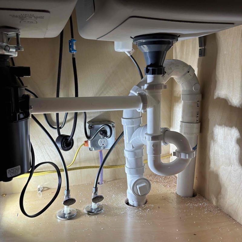 Sink drain and P-trap plumbing installation under cabinet