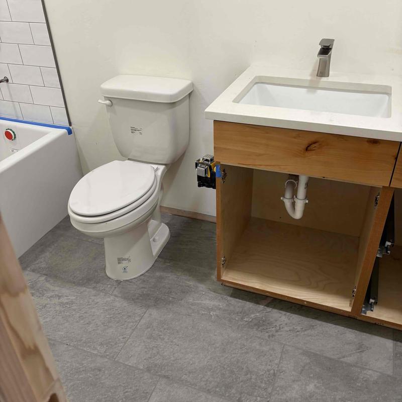 Bathroom sink drain and toilet installation in progress