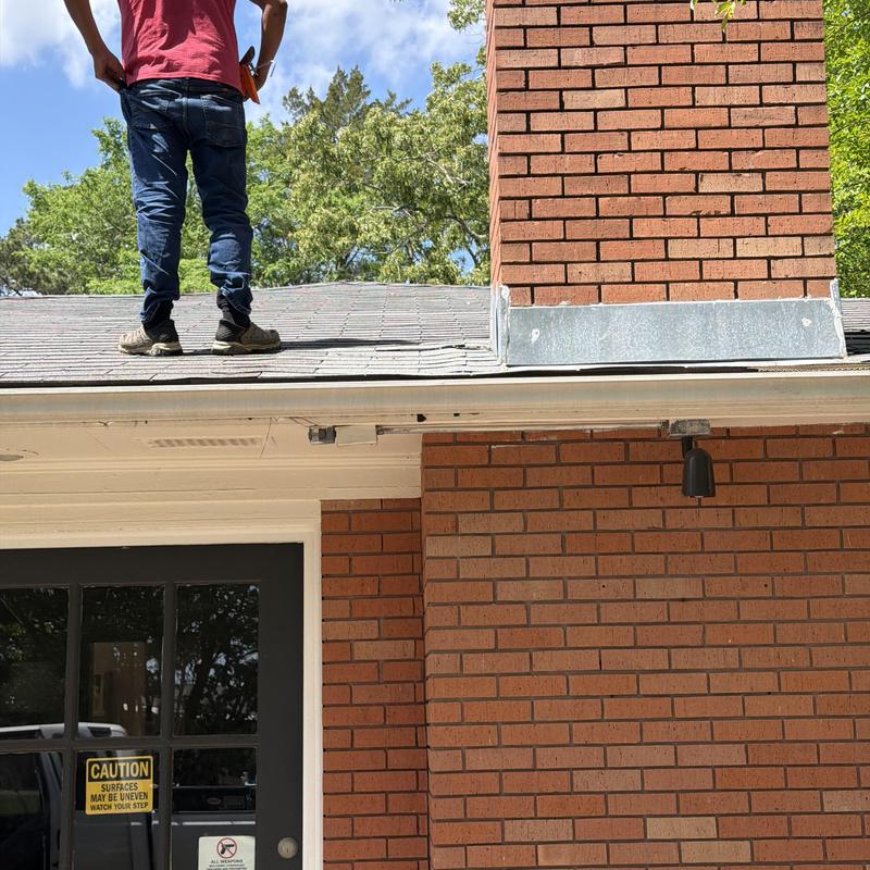 Asphalt shingle roof with chimney flashing near door