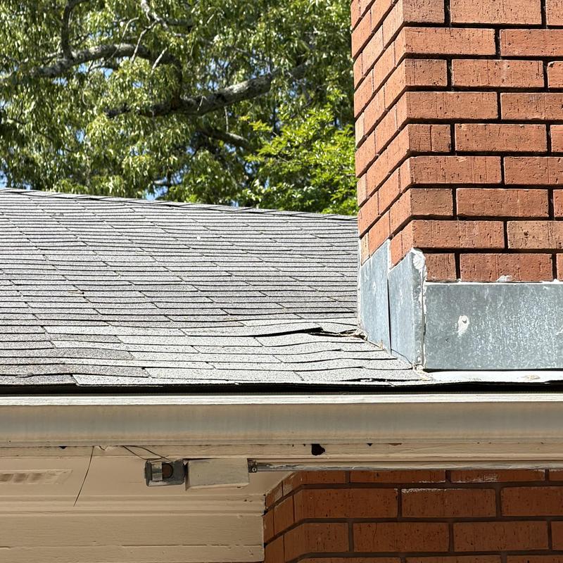 Asphalt shingle roof near brick chimney damage Pearl MS