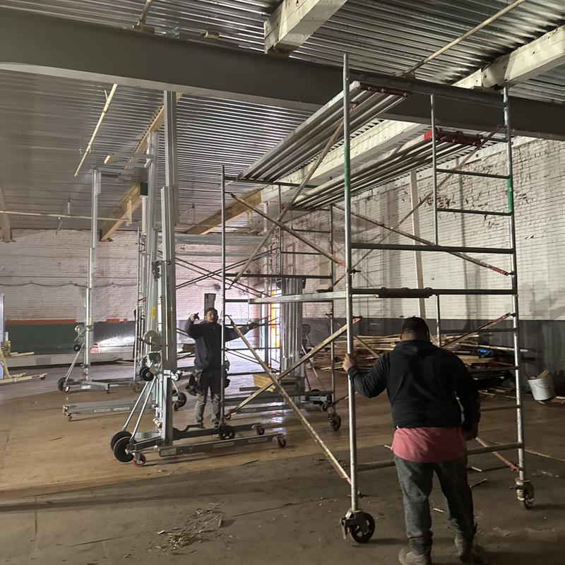 Metal decking installation with scaffolding setup in warehouse