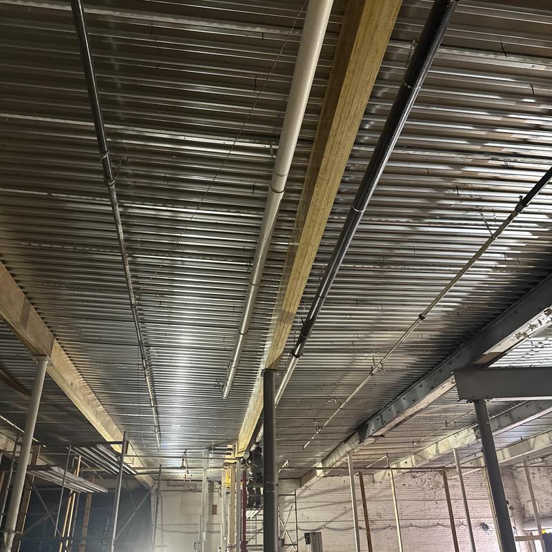 Metal decking installation over structural beams in progress
