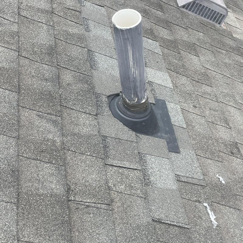 Plumbing vent pipe flashing and sealant on shingle roof