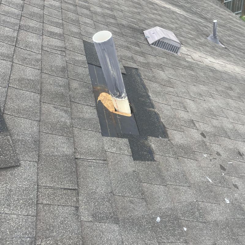 Plumbing vent pipe with damaged flashing on shingle roof