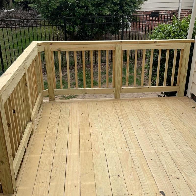 Wooden deck flooring and railing installation in backyard